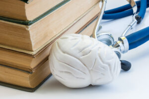 mental health books next to a brain