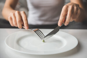 anorexic woman eating a pea