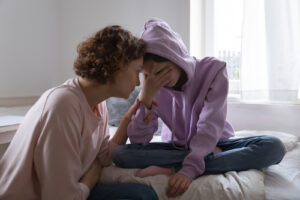 mom comforting teen after fight with friend
